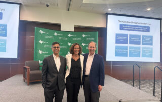 Dhruv Maniktala, CIO, Partner, True North Advisors & Western Alternative Strategies (left), Laura Minch, CEO, CFA Society, DFW (center), and Gregg Ballew (right) stop for a photo in front of the UT Dalls branded backdrop and stage during UTD’s Institute for Excellence in Corporate Governance.