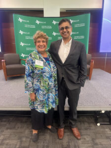 Niki McCuistion (left) and Dhruv Maniktala, CIO, Partner, True North Advisors & Western Alternative Strategies (right) stop to take a photo infront of the UT Dallas backdrop and stage.